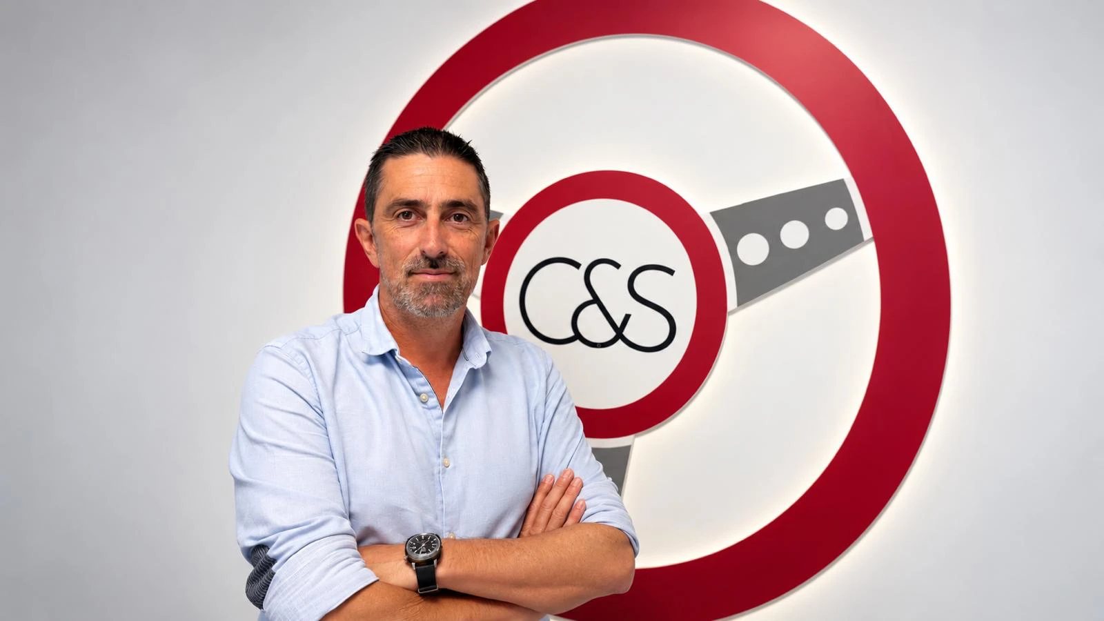 Christophe, fondateur de CAR&SENS, devant le volant du showroom